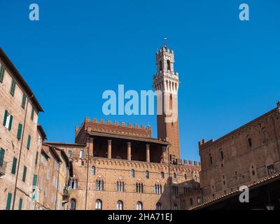 Torre del Mangia und Loggia dei Nove des Palazzo Pubblico oder Palazzo Comunale in Siena. Toskana, Italien, von der Piazza del Mercato aus gesehen Stockfoto