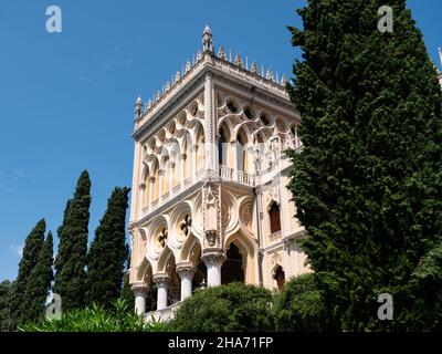 Villa Borghese auf der Insel Isola del Garda, ein Palast in einer Fassade im venezianischen neugotischen Stil mit Palmen Stockfoto