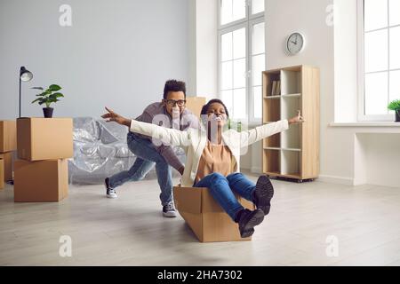 Fröhliches junges Paar, das in sein erstes eigenes Haus zieht und Spaß und Freude hat. Stockfoto