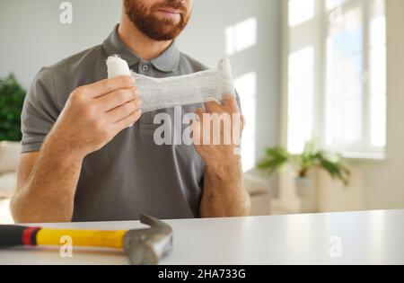 Der Mann legte einen Verband auf den Finger, der ein Handtrauma hatte Stockfoto