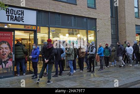 Vor Rough Trade in Bristol stehen Menschen Schlange, wo ein T-Shirt des Straßenkünstlers Banksy verkauft wird, um vier Personen zu unterstützen, die vor Gericht gestellt werden, weil sie wegen des Abstürzens einer Statue des Sklavenhändlers Edward Colston angeklagt sind. Bilddatum: Samstag, 11. Dezember 2021. Stockfoto