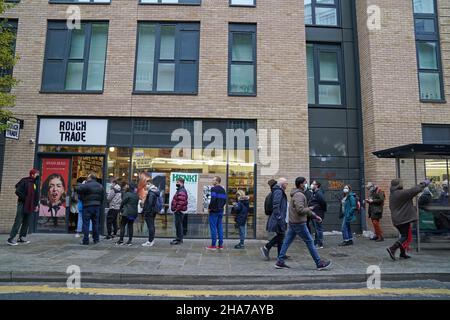 Vor Rough Trade in Bristol stehen Menschen Schlange, wo ein T-Shirt des Straßenkünstlers Banksy verkauft wird, um vier Personen zu unterstützen, die vor Gericht gestellt werden, weil sie wegen des Abstürzens einer Statue des Sklavenhändlers Edward Colston angeklagt sind. Bilddatum: Samstag, 11. Dezember 2021. Stockfoto