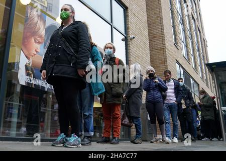 Vor Rough Trade in Bristol stehen Menschen Schlange, wo ein T-Shirt des Straßenkünstlers Banksy verkauft wird, um vier Personen zu unterstützen, die vor Gericht gestellt werden, weil sie wegen des Abstürzens einer Statue des Sklavenhändlers Edward Colston angeklagt sind. Bilddatum: Samstag, 11. Dezember 2021. Stockfoto