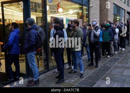 Vor Rough Trade in Bristol stehen Menschen Schlange, wo ein T-Shirt des Straßenkünstlers Banksy verkauft wird, um vier Personen zu unterstützen, die vor Gericht gestellt werden, weil sie wegen des Abstürzens einer Statue des Sklavenhändlers Edward Colston angeklagt sind. Bilddatum: Samstag, 11. Dezember 2021. Stockfoto