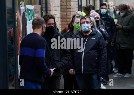 Vor Rough Trade in Bristol stehen Menschen Schlange, wo ein T-Shirt des Straßenkünstlers Banksy verkauft wird, um vier Personen zu unterstützen, die vor Gericht gestellt werden, weil sie wegen des Abstürzens einer Statue des Sklavenhändlers Edward Colston angeklagt sind. Bilddatum: Samstag, 11. Dezember 2021. Stockfoto