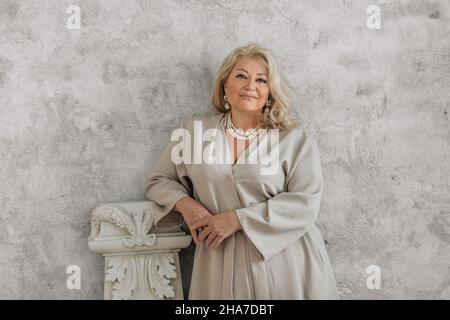Auffällige, ältere Frau steht und schaut in die Kamera. Stockfoto