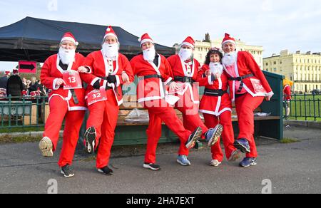 Brighton UK 11th December 2021 - Hunderte von Läufern nehmen in diesem Jahr an Brighton Santa Dash an der Küste von Hove Teil, das Geld für die Rockinghorse-Wohltätigkeitsorganisation sammelt : Credit Simon Dack / Alamy Live News Stockfoto