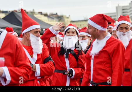 Brighton UK 11th December 2021 - Hunderte von Läufern nehmen in diesem Jahr an Brighton Santa Dash an der Küste von Hove Teil, das Geld für die Rockinghorse-Wohltätigkeitsorganisation sammelt : Credit Simon Dack / Alamy Live News Stockfoto