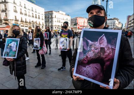 Madrid, Spanien. 11th Dez 2021. Tierrechtler, die Bilder von Tieren in Farmen tragen, protestieren gegen den Tiermissbrauch, der von der Gruppe „Animal Equality“ (Igualdad Animal) aufgerufen wurde und die Auswirkungen von Nutztierbeständen auf den Planeten anprangert. Quelle: Marcos del Mazo/Alamy Live News Stockfoto