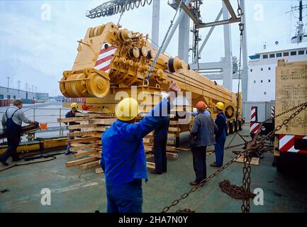 Schwere Ladung, ein mobiler Kran, wird auf das Oberdeck eines Ro-Ro-Schiffes im Hamburger Hafen verladen. Stockfoto