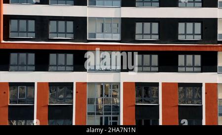 Luftaufnahme eines neuen modernen, farbenfrohen Hochhauses, Urbanisierungskonzept und Architektur. Video. Orange und schwarze mehrstöckige Wohnanlage Stockfoto