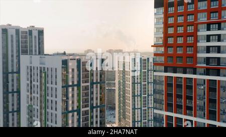 Luftaufnahme eines großen Stadtteils mit sonnigen Straßen und hohen Wohngebäuden auf bewölktem Himmel Hintergrund. Video. Schöne bunte Stadt sind Stockfoto