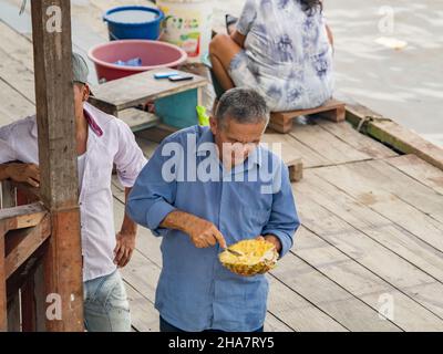 Caballococha, Peru - Dec 11, 2017: Porträt eines Mannes essen Ananas vom Löffel. Stockfoto