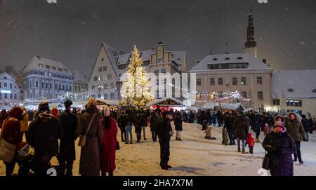 Tallinns Weihnachtsmarkt auf dem zentralen Marktplatz der Altstadt (Raekojaplats). Tallinns Rathausplatz während der Feiertage und Schneefall. Stockfoto