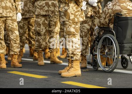 Rumänische Armee Veteranen Soldaten, von denen einer verletzt und behindert ist, sitzen in einem Rollstuhl, bereiten sich auf die rumänische Nationalfeiertag Militärparade. Stockfoto