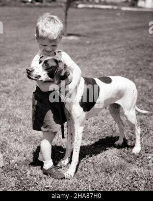 1950S BLONDE JUNGE KLEINKIND UMARMT POINTER HUND UND LÄCHELND - D8 HAR001 HARS UMARMT S&W KLEINKIND POINTER GLÜCK SÄUGETIERE UND HUNDE POOCH FREUNDLICHES BABY JUNGE PERSÖNLICHE BINDUNG ANGENEHME ZUNEIGUNG SYMPATHISCHER HUND CHARMANTE EMOTION JUGENDLICHE LIEBENSWERTE SÄUGETIERE ANGENEHME ZWEISAMKEIT LIEBENSWERT ANSPRECHENDE SCHWARZ-WEISSE KAUKASISCHE ETHNIE HAR001 ALTMODISCH Stockfoto