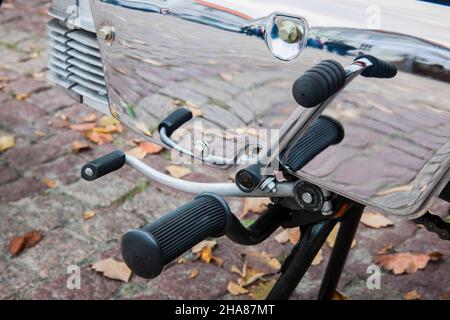 Detailansicht der Gangschaltung, der Fußstütze des Kick-Starters und des Kick-Starters auf der spiegelglatt polierten Getriebeabdeckung eines alten Mopeds deutscher Herkunft. Stockfoto