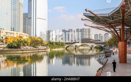 Älterer Mann, der Tai Chi praktiziert, mit ikonischem Blick auf die Anshun-Brücke über den Jinjiang-Fluss in Chengdu (eine Mega-Stadt in Sichuan, China), mit Modus Stockfoto