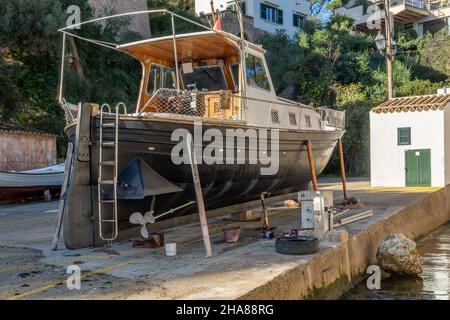 Freizeitboot unterstützt auf Metallstativen für zukünftige Restaurierung. Cala Figuera Marina, Insel Mallorca, Spanien Stockfoto