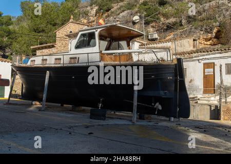 Freizeitboot unterstützt auf Metallstativen für zukünftige Restaurierung. Cala Figuera Marina, Insel Mallorca, Spanien Stockfoto