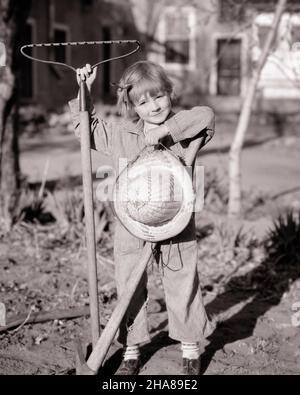 1930S NIEDLICHES KLEINES MÄDCHEN, DAS IM GARTEN STEHT UND DIE KAMERA MIT HICKORY-STREIFEN-OVERALLS MIT STROH HUT PICK AX UND ANSCHAUT RAKE - J5764 HAR001 HARS GLÜCKLICH FREUDE LIFESTYLE PICK FRAUEN LÄNDLICHEN RAKE HOME LEBEN STREIFEN KOPIE RAUM IN VOLLER LÄNGE INSPIRATION FÜRSORGLICH VERTRAUEN LANDWIRTSCHAFT B&W BLICKKONTAKT TRÄUME GLÜCK FRÖHLICHE ABENTEUER PFLICHT FREIZEIT KRAFT UND AUSWAHL AUFREGUNG ERHOLUNG STOLZ AUF GELEGENHEIT LÄCHELT KONZEPTUELLE PHANTASIE FREUDIG STILVOLLE HICKORY AX KREATIVITÄT WACHSTUM IDEEN JUGENDLICHE ENTSPANNUNG AUFGABE SCHWARZ UND WEISS KAUKASISCHEN ETHNIZITÄT OVERALLS HAR001 ALT MODISCH Stockfoto