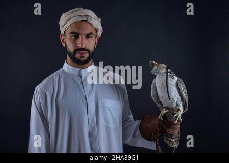Junger Falkner, der einen Raubvögel hält. Stockfoto