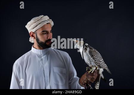 Junger Falkner, der einen Raubvögel hält. Stockfoto