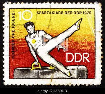 DDR - UM 1970: Eine in der DDR gedruckte Briefmarke zeigt Sportler auf dem Pommelpferd, 3rd Kinder- und Jugendspartakiad, um 1970 Stockfoto