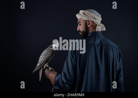 Junger Falkner, der einen Raubvögel hält. Stockfoto