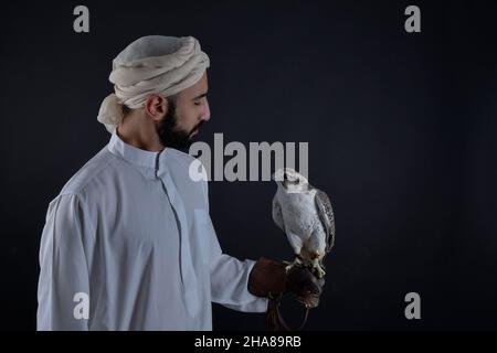 Junger Falkner, der einen Raubvögel hält. Stockfoto