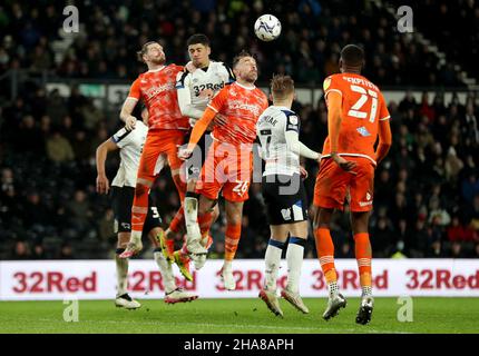 Richard Keogh (Mitte) von Blackpool steht während des Sky Bet Championship-Spiels im Pride Park Stadium, Derby, auf dem Kopf. Bilddatum: Samstag, 11. Dezember 2021. Stockfoto