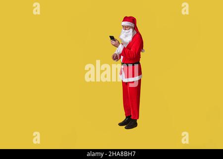 weihnachtsmann gelb stilvoll, Urlaub weihnachten Jahr Senior, Anzug Menschen. Reif, weiß mit Telefon in der Hand Stockfoto