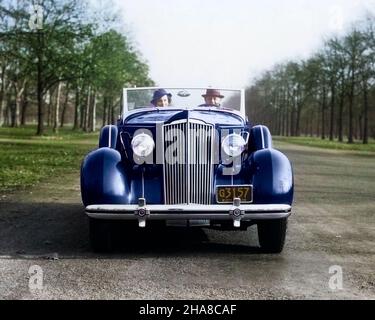 1930S SONNTAG FAHRT PAAR MANN UND FRAU BEIM KAMERAFAHREN 1935 PACKARD CABRIO AUTO - M2769C HAR001 HARS EHEPARTNER EHEMÄNNER ERWACHSEN TRANSPORT KOPIEREN RAUM FREUNDSCHAFT DAMEN PERSONEN ERWACHSEN AUTO MÄNNER TRANSPORT PARTNER AUGE KONTAKT KOPF UND SCHULTERN KRAFTFAHRZEUG AUTOS IM AUTOVERKEHR SONNTAG FAHREN AUTOS MOBILITÄT FAHRZEUGE 1935 PACKARD ZWEISAMKEIT FRAUEN JUNGER ERWACHSENER MANN JUNGER ERWACHSENER FRAU KAUKASISCHE ETHNIE HAR001 ALTMODISCH Stockfoto