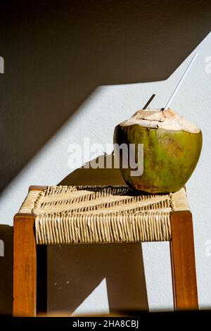 Frische Kokosnuss auf Hocker mit Schatten Stockfoto