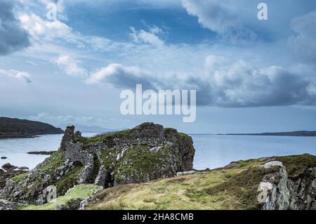 Die Ruinen der mittelalterlichen Burg Dunscaith gegen das Meer und Wolken Stockfoto