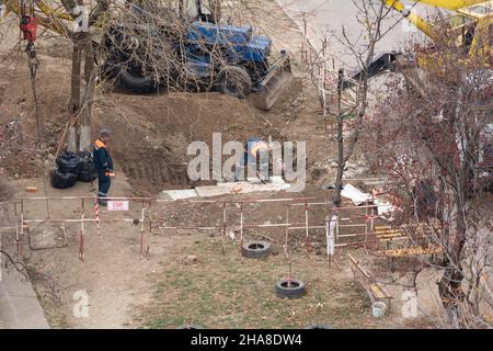 Tiraspol, nicht anerkannte Republik Transnistrien - 18. November 2021 Ein Team von Arbeitern führt Reparaturarbeiten an einem Heizungsnetz in einem Wohngebiet aus Stockfoto