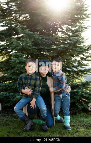 Porträt von Mutter und Söhnen vor dem weihnachtsbaum Stockfoto