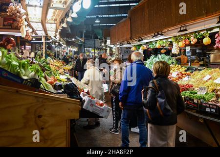 Menschen, die an den Obst- und Gemüseständen auf dem überdachten Orientalischen Markt von Genua (MOG), Ligurien, Italien einkaufen Stockfoto