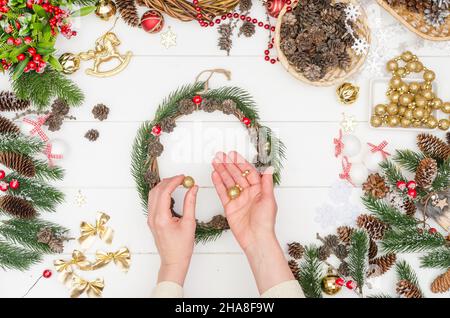 Schritt für Schritt einen kleinen Weihnachtskranz machen, Schritt 7 - Nehmen Sie Goldperlen in verschiedenen Größen Stockfoto