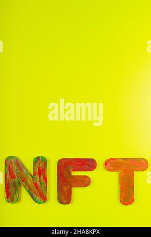 Nicht fungibler Token. NFT Akronym für mehrfarbige Buchstaben auf gelbem Hintergrund. Crypto Art Konzept. Speicherplatz kopieren. Draufsicht Stockfoto