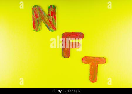 Nicht fungibler Token. NFT Akronym für mehrfarbige Buchstaben auf gelbem Hintergrund. Crypto Art Konzept. Speicherplatz kopieren. Draufsicht Stockfoto