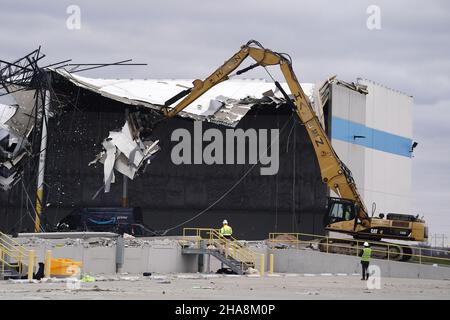 Edwardsville, Usa. 11th Dez 2021. Am Samstag, den 11. Dezember 2021, entfernt eine Maschinerie das, was von einer Wand am Amazon Hub in Edwardsville, Illinois, übrig ist. Ein starker Tornado am Freitag, den 10. Dezember 2021, plante das Fußballwerk und ließ zwei Tote und mehrere Mitarbeiter vermissen. Foto von Bill Greenblatt/UPI Credit: UPI/Alamy Live News Stockfoto