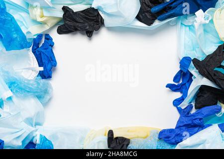 Verschwendung von gebrauchter persönlicher Schutzausrüstung PSA-Handschuhe, Einwegmasken, Schuhüberzüge von medizinischem Personal in Form eines Hintergrunds. Garbage Contamin Stockfoto