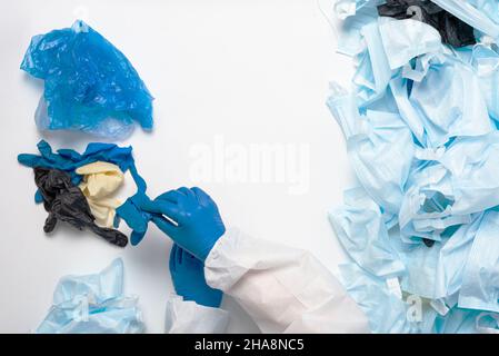 Sortierung von medizinischem Abfall nach Coronavirus. Separate Kollektion von Überziehschuhen, medizinischen Handschuhen und Masken. Stockfoto