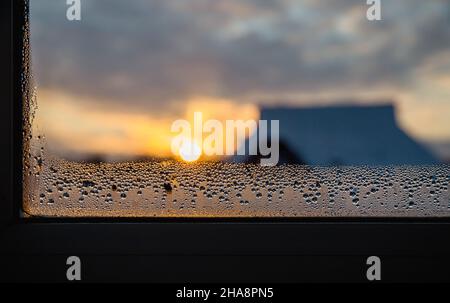 Im Winter fällt am Morgen Kondenswasser auf die Fenster des Hauses. Konzept für hohe Luftfeuchtigkeit. Stockfoto