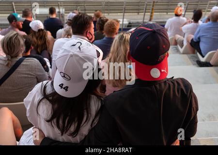 Die Fans der beiden rivalisierenden Teams Redbull und Mercedes sind das geliebte Paar, das das Formel-Rennen mit Hüten des Grand Prix von Abu Dhabi F1 beobachtet Stockfoto