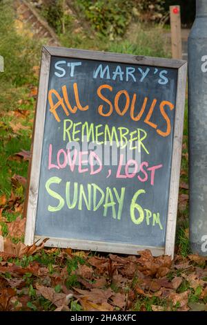 Hinweis an der Tafel über den All Souls Day vor einer Kirche in Surrey, Großbritannien. Erinnern Sie sich geliebt verloren. Stockfoto