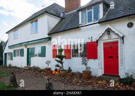 16 und 18, The Street, Shalford, Surrey, England, VEREINIGTES KÖNIGREICH. Denkmalgeschütztes Gebäude der Klasse II, Cottages aus dem 17th. Jahrhundert mit farbenfrohen Türen und Fensterläden im Dorf Stockfoto