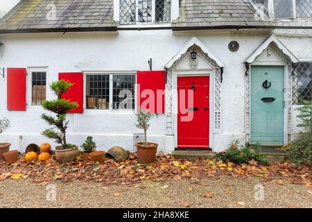 16 und 18, The Street, Shalford, Surrey, England, VEREINIGTES KÖNIGREICH. Denkmalgeschütztes Gebäude der Klasse II, Cottages aus dem 17th. Jahrhundert mit farbenfrohen Türen und Fensterläden im Dorf Stockfoto