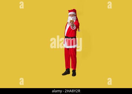 weihnachtsmann gelbe Nahrung groß, Zahnspange schnell Jahr gealtert, Anzug alt. Hut bärtig fröhlich, Diät isst eine Banane mit der rechten Hand Stockfoto